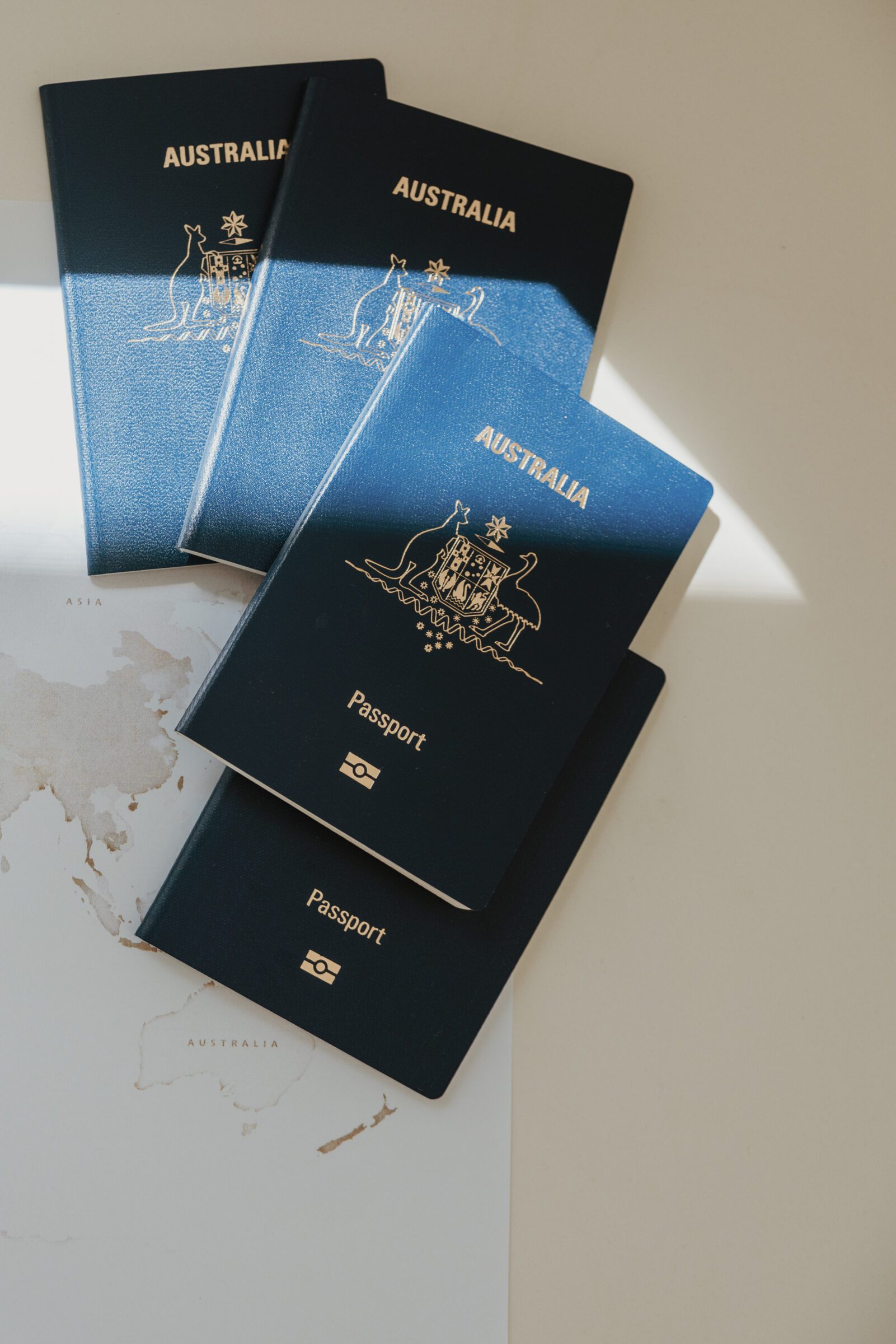 Four passports laid out on a world map on a table, symbolizing the organization of important documents as a crucial part of how to plan for a family vacation, ensuring all travel paperwork is in order before embarking on a family trip.