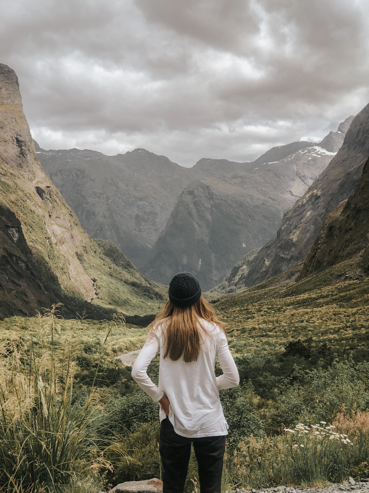 Woman in a New Zealand national park looking at mountain views, demonstrating that parents can pursue their travel dreams even with kids, embodying the idea that travel doesn't have to stop once you have a family, and everyone's interests can be part of the journey.