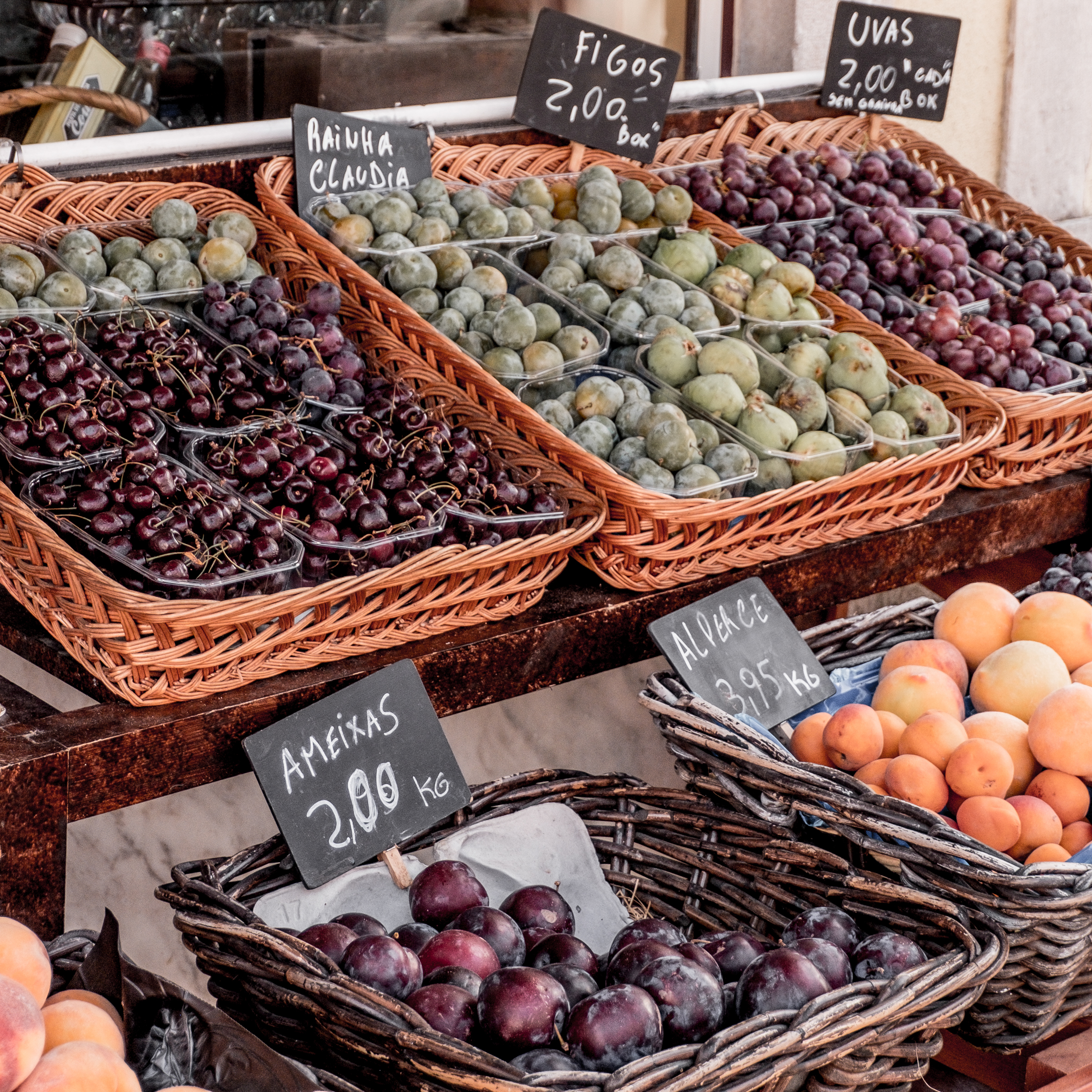 Local fruit displayed in crates at a farmers market, underscoring the tip for packing for travel with kids: researching local food options in advance to introduce children to new foods gradually, enriching the travel experience through culinary exploration.