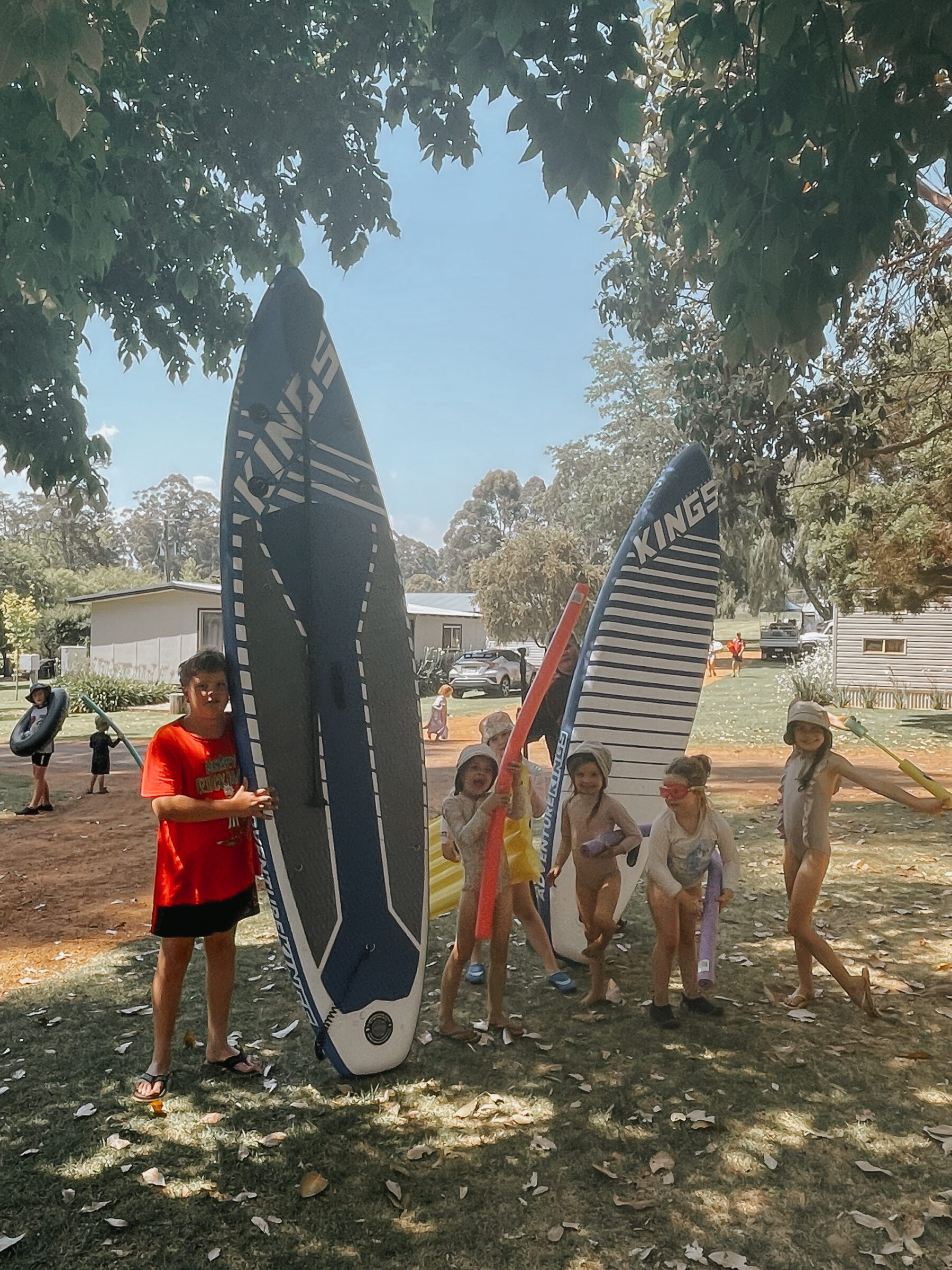 Group of young children on holiday, heading to the swimming pool in their bathers, clutching pool toys, illustrating the savings benefits of traveling with another family. This approach, where families share accommodations like an Airbnb or pool resources for transportation, can significantly reduce costs, making the vacation more enjoyable and economically friendly.