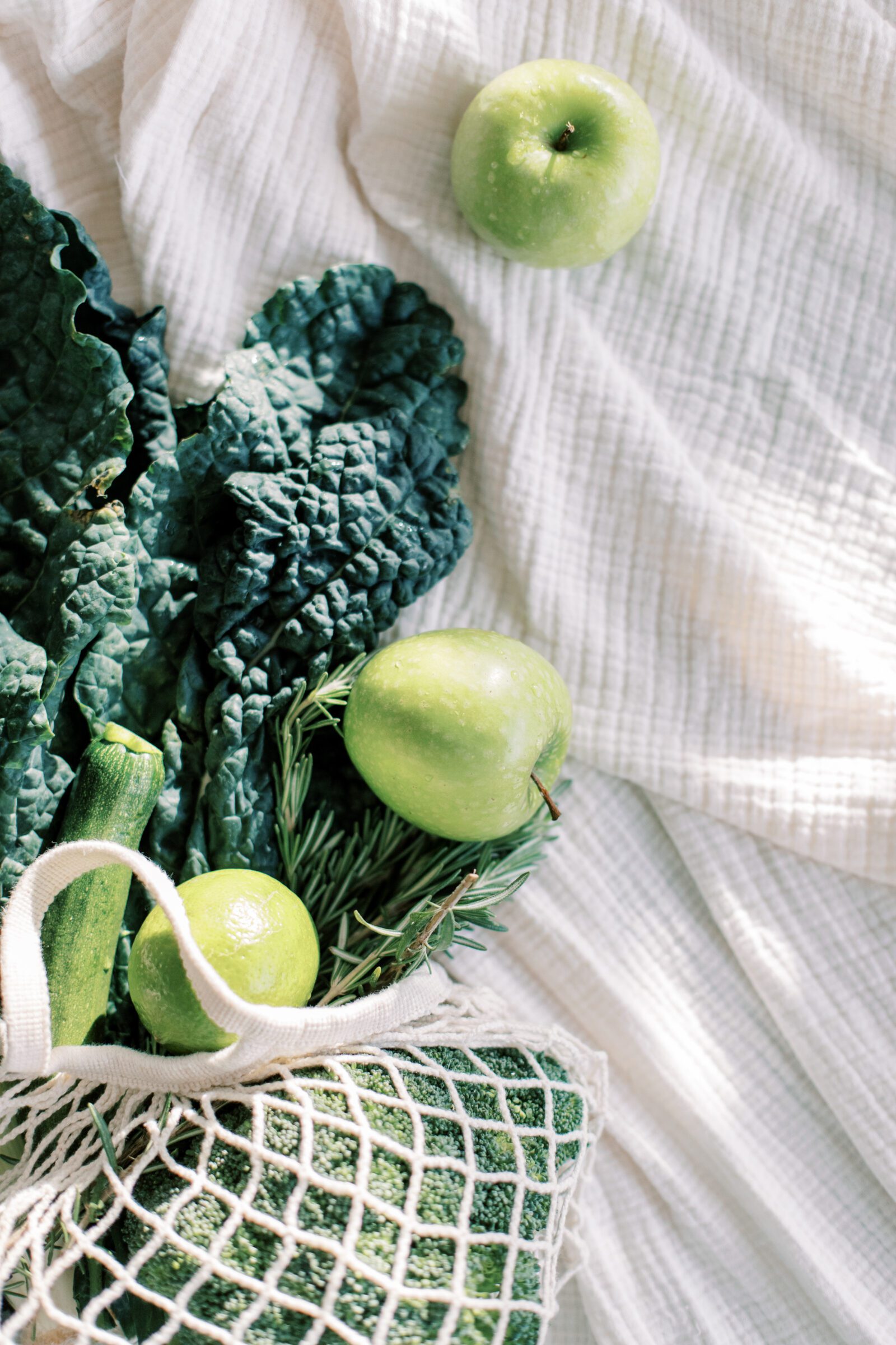 Bag of fresh green fruit and vegetables, illustrating a clever budgeting trick for affording your next family vacation. This image represents how reallocating typical household expenses like groceries and fuel to your travel budget can significantly boost your funds.