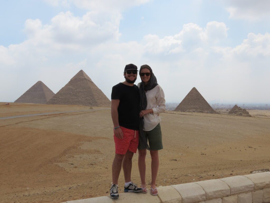 Rachel and Matt standing in front of the pyramids of Egypt, the country in which they needed a flexible money system after they ran out of cash and had to borrow from a friend.