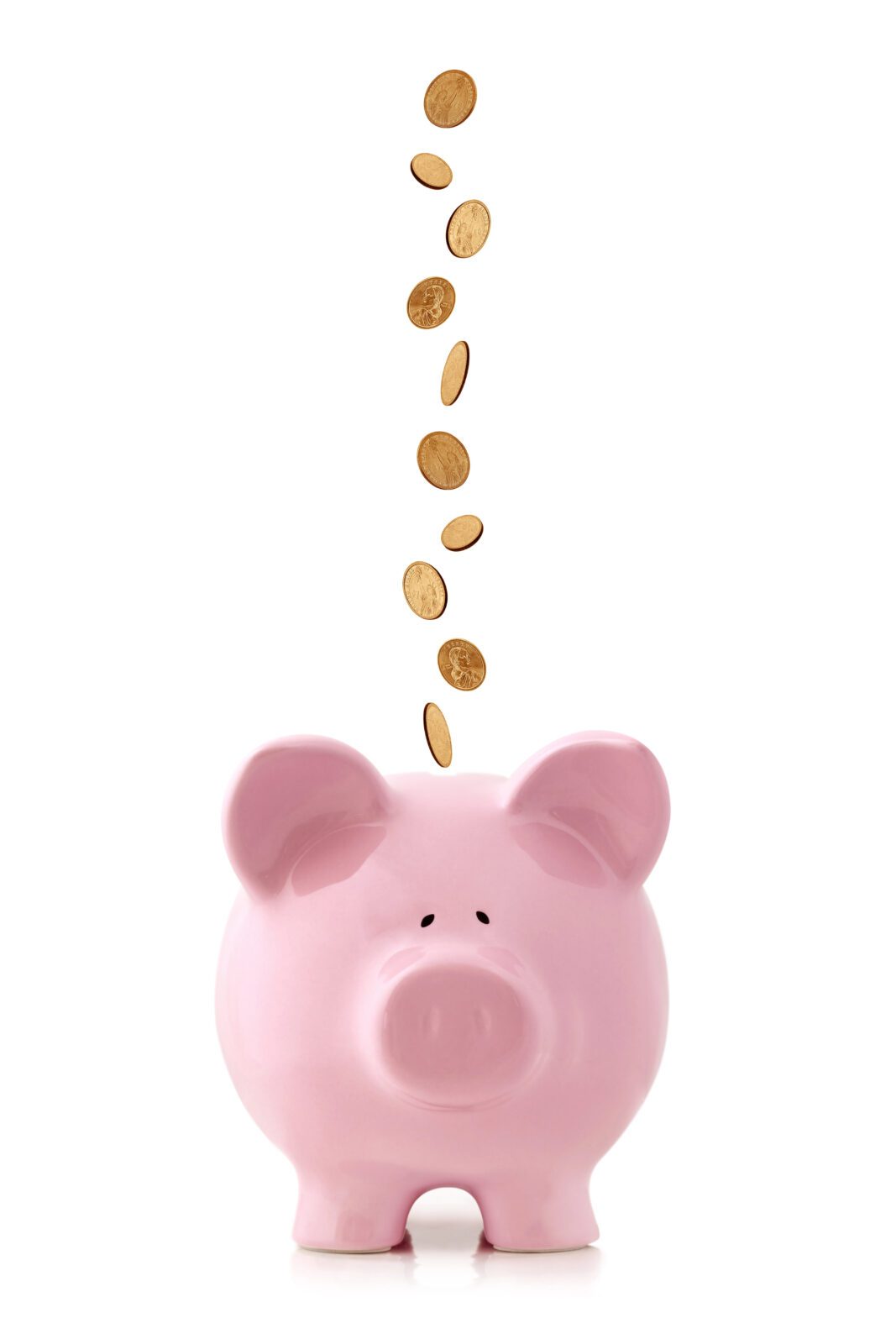 Pink piggy bank on a white table with coins falling in. Represents building flexibility and protecting your travel savings while planning family trips.